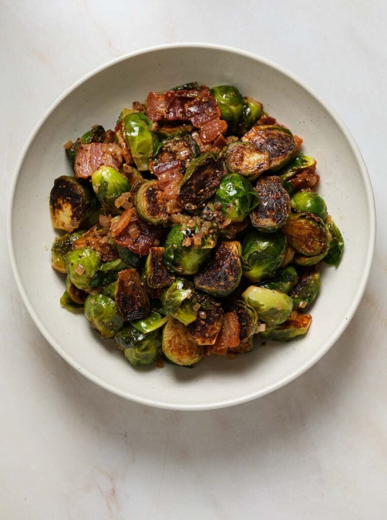 A bowl of cooked, halved brussels sprouts.