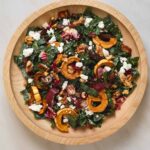 A wooden salad bowl filled with salad.