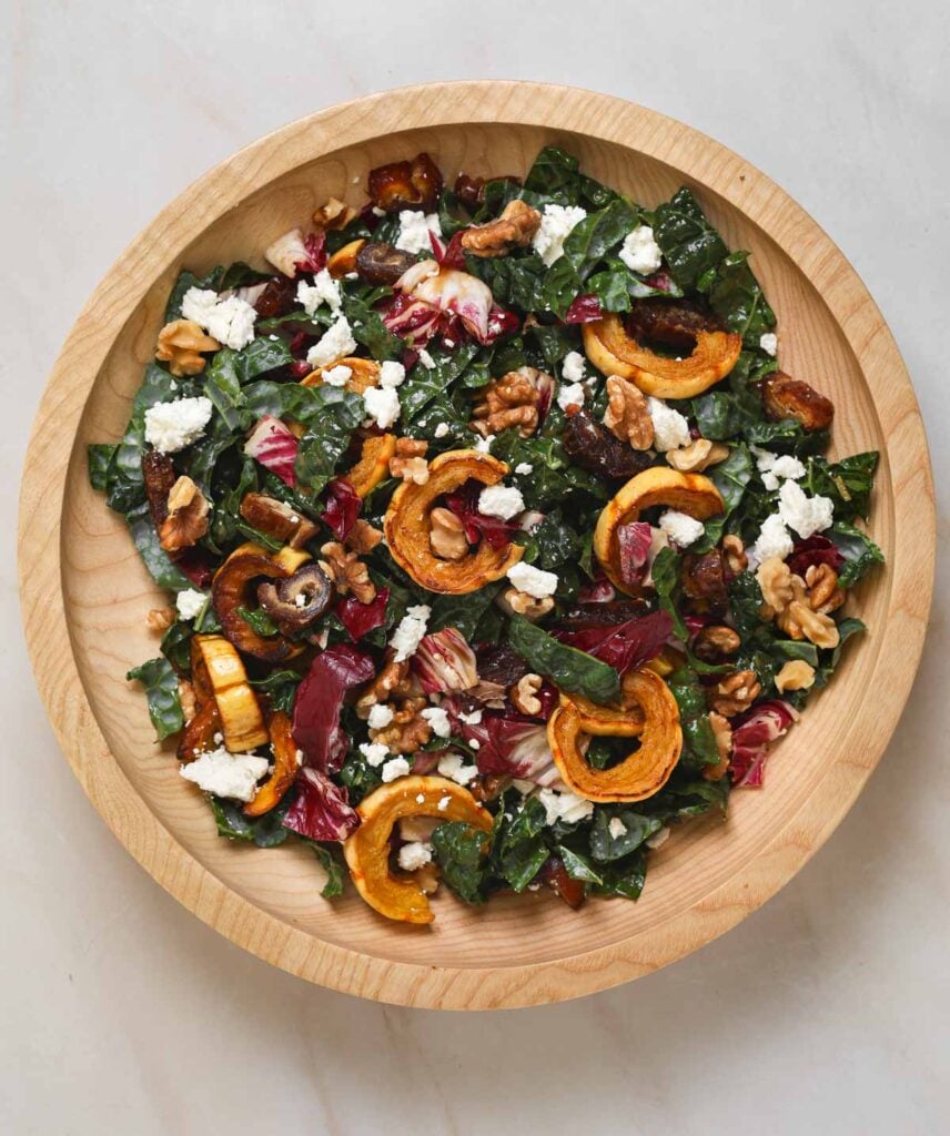 A wooden salad bowl filled with salad.